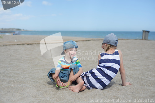 Image of Little boy and girl sitting on the beach