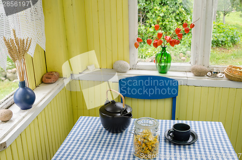 Image of rural room and ceramic tea set calendula on table 