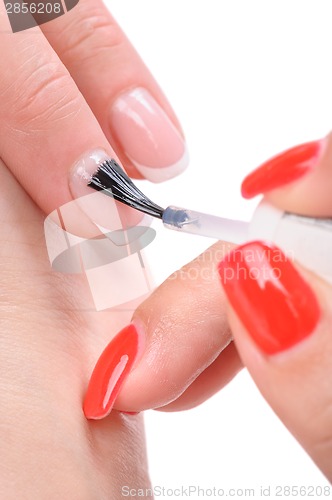 Image of manicure, applying clear enamel