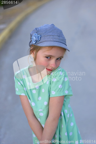 Image of Blonde young kid in denim cap  and dress