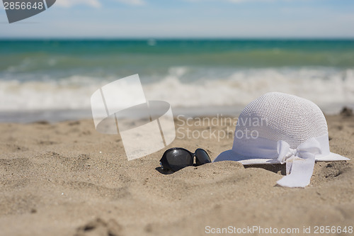 Image of Wicker hat and sunglasses on the beach