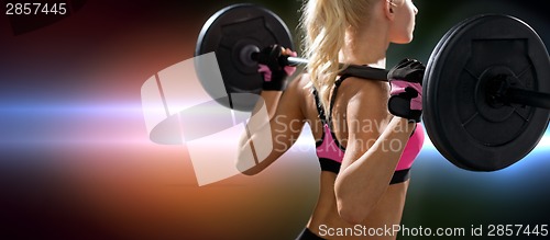 Image of sporty woman exercising with barbell from back