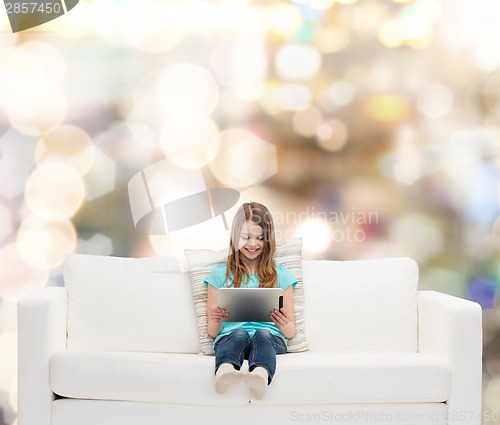 Image of little girl sitting on sofa with tablet pc