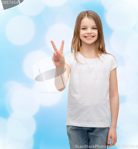 Image of little girl in white t-shirt showing peace gesture