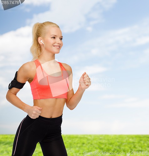 Image of sporty woman running with smartphone and earphones