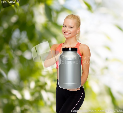 Image of smiling sporty woman with jar of protein