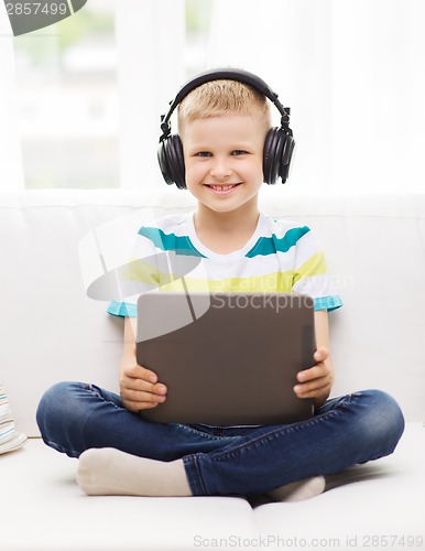 Image of little boy with tablet pc and headphones at home
