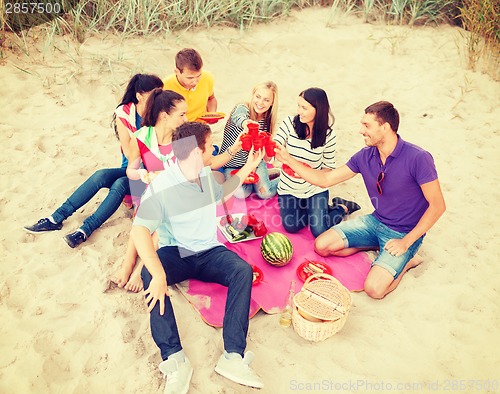 Image of group of friends celebrating birthday on beach