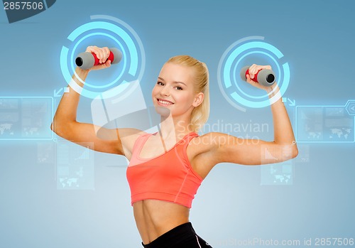 Image of smiling beautiful sporty woman with dumbbells