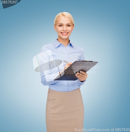 Image of smiling businesswoman with clipboard and pen