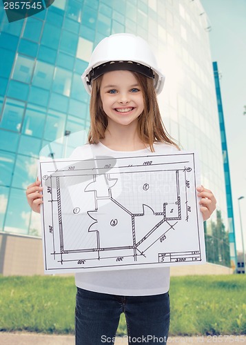 Image of smiling little girl in helmet showing blueprint