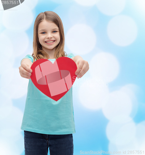 Image of smiling little girl giving red heart