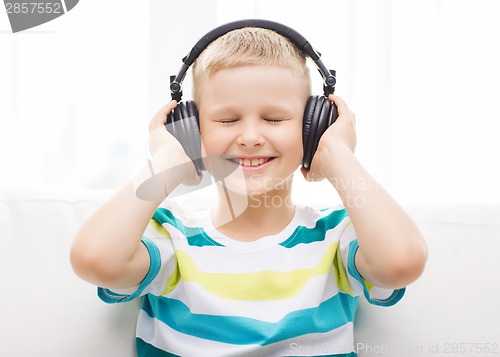 Image of smiling little boy with headphones at home