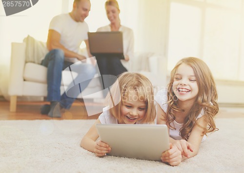 Image of smiling sister with tablet pc and parents on back