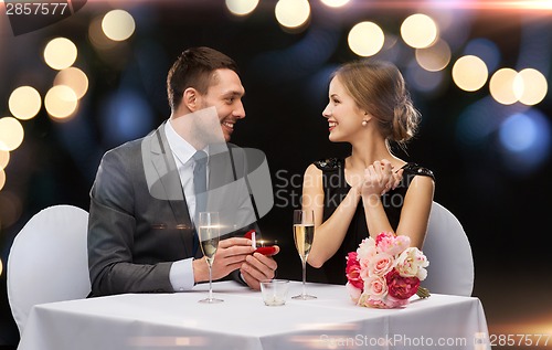 Image of man proposing to his girlfriend at restaurant