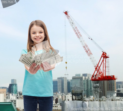 Image of smiling little girl giving dollar cash money