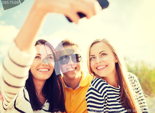 Image of friends taking picture with smartphone camera