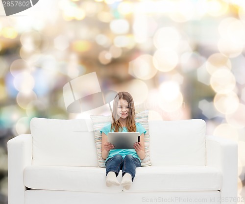 Image of little girl sitting on sofa with tablet pc