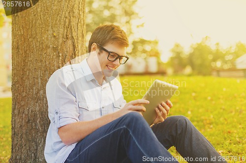 Image of smiling male student in eyeglasses with tablet pc