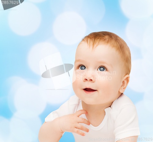 Image of smiling baby lying on floor and looking up