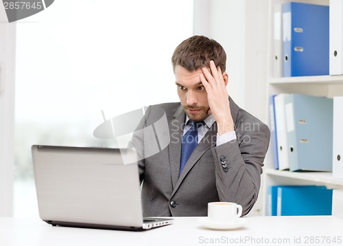 Image of busy businessman with laptop and coffee