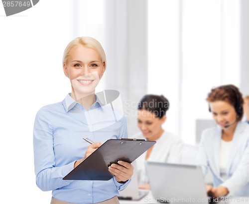 Image of smiling businesswoman with clipboard and pen