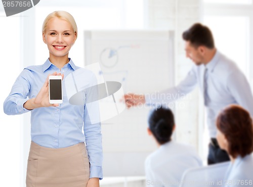 Image of smiling businesswoman with smartphone blank screen