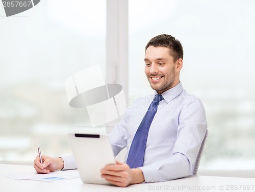 Image of smiling businessman with tablet pc and documents