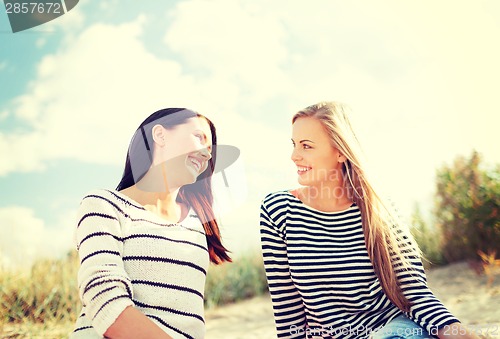 Image of smiling girlfriends having fun on the beach