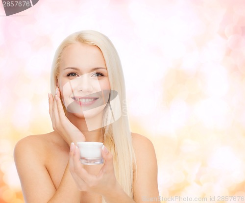 Image of woman applying cream on her skin