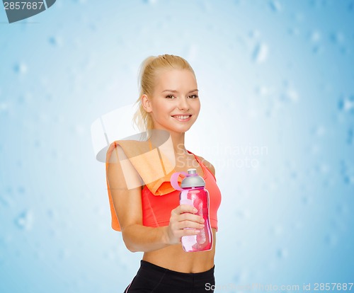 Image of smiling sporty woman with water bottle and towel