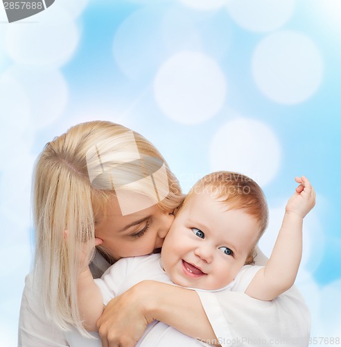Image of happy mother kissing smiling baby