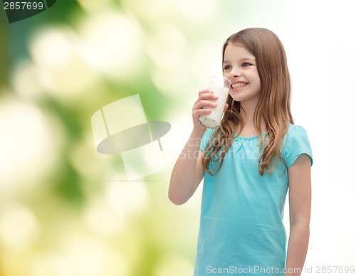 Image of smiling little girl drinking milk out of glass