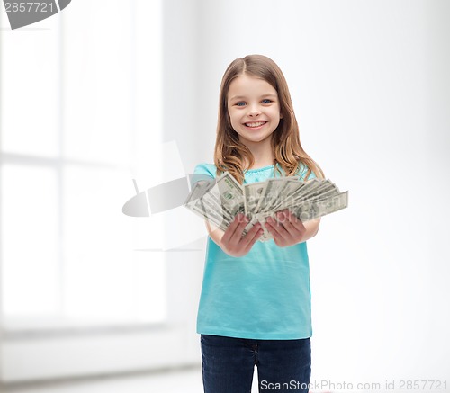 Image of smiling little girl giving dollar cash money