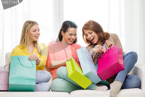 Image of smiling teenage girls with many shopping bags