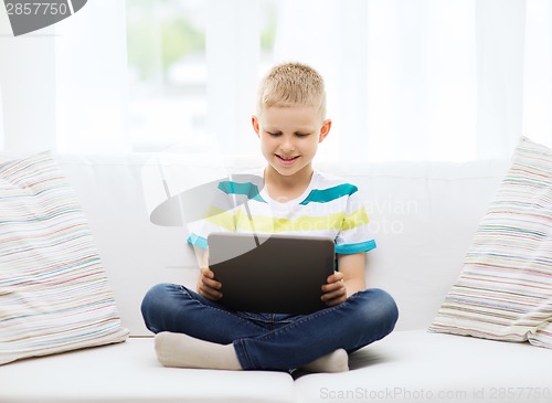 Image of smiling boy with tablet computer at home