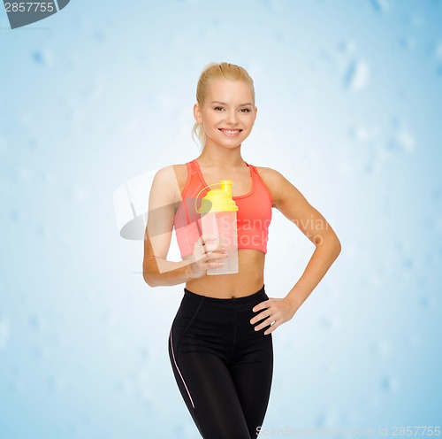 Image of smiling sporty woman with protein shake bottle