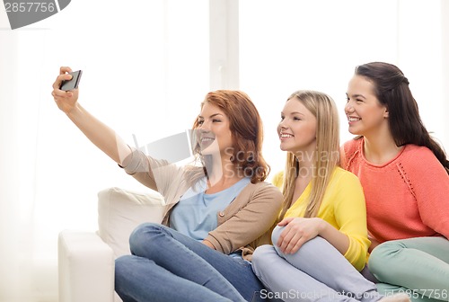 Image of teenage girls taking selfie with smartphone