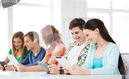 Image of smiling students with tablet pc at school