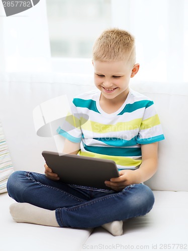 Image of smiling boy with tablet computer at home