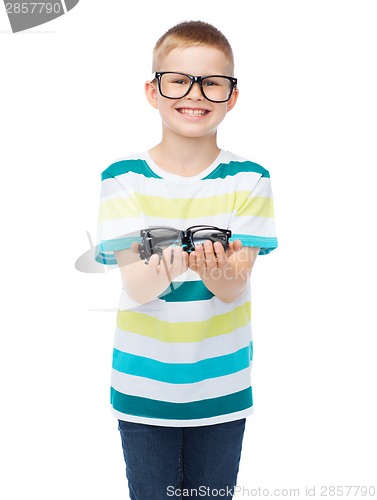 Image of smiling boy in eyeglasses holding spectacles