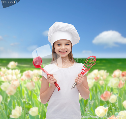 Image of smiling girl in cook hat with ladle and whisk