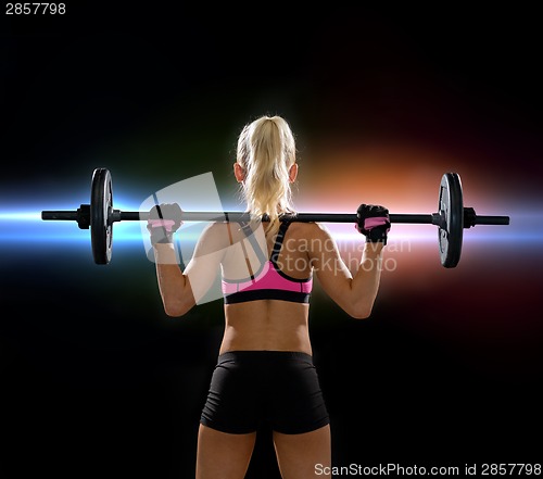 Image of sporty woman exercising with barbell from back