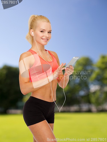 Image of smiling sporty woman with smartphone and earphones