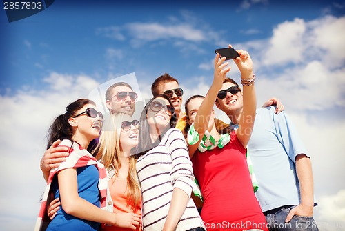 Image of group of friends taking picture with smartphone