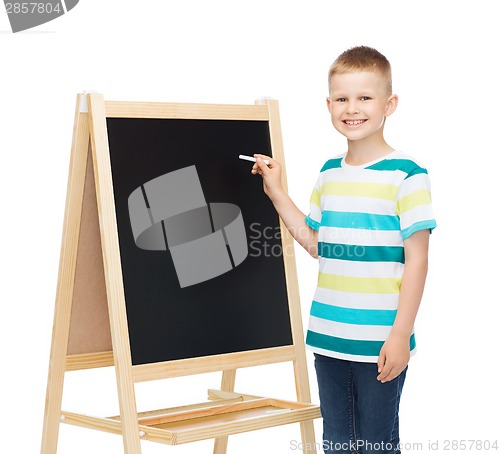 Image of happy little boy with blackboard and chalk