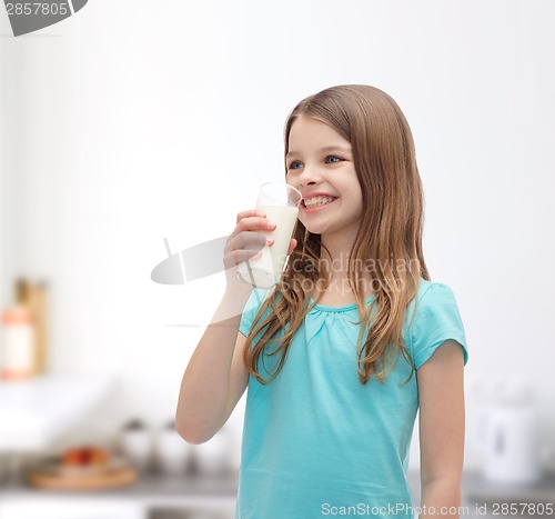 Image of smiling little girl drinking milk out of glass