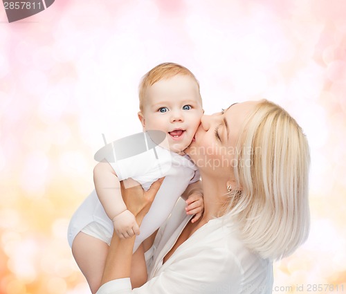 Image of happy mother kissing smiling baby