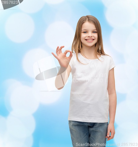 Image of little girl in white t-shirt showing ok gesture