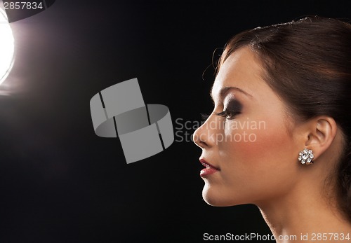 Image of profile portrait of woman with diamond earrings